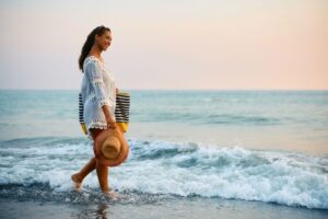 A woman walking along the beach, one of the best things to do in 30A on a solo vacation.